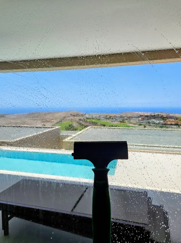 Squeegee on terrace glass overlooking the pool and the sea